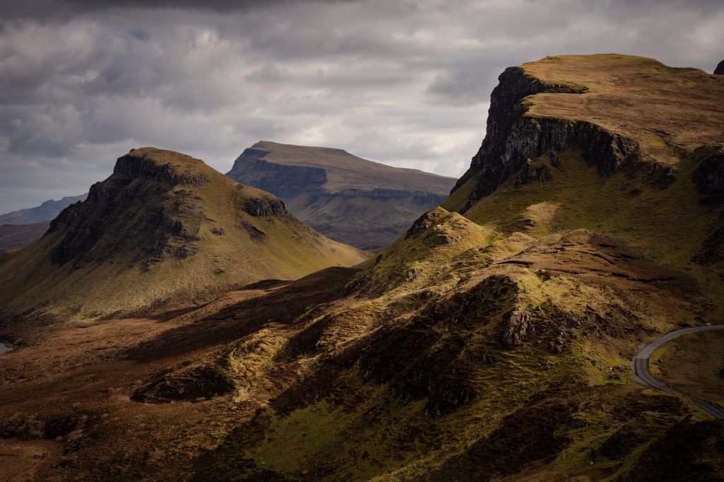 A dramatic ridge line with dark clouds in the sky.